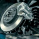 Scheibenbremse des Fahrzeugs für die Reparatur, in den Prozess der neuen Reifen Ersatz. Auto Bremse Reparatur in garage.suspension des Autos für die Wartung Bremsen und Stoßdämpfer-Systeme. Nahaufnahme.